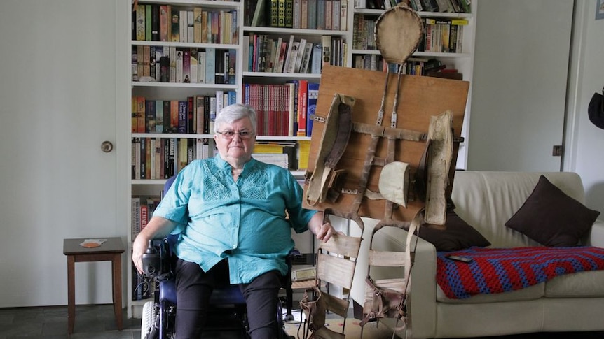 Ann-Maree Higgins McLeod sitting in a wheelchair, holding a full-body splint