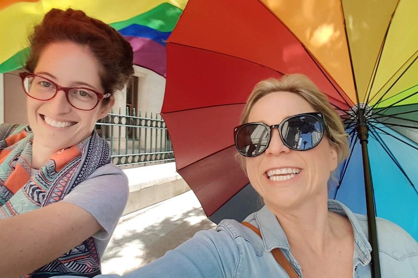 Two women smile at the camera.