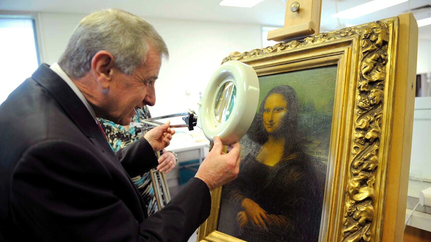 Arts Minister Simon Crean inspects the fake Mona Lisa at the National Library of Australia.