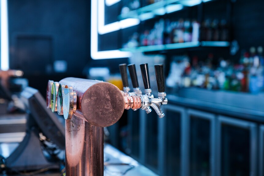 A close-up shot of drink taps at the bar inside a nightclub.
