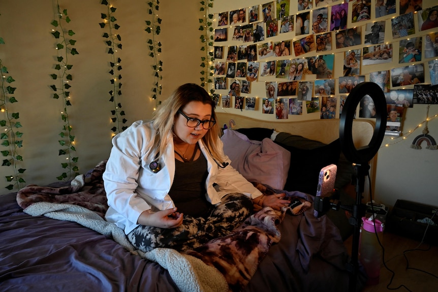 A woman films a TikTok video from her bedroom