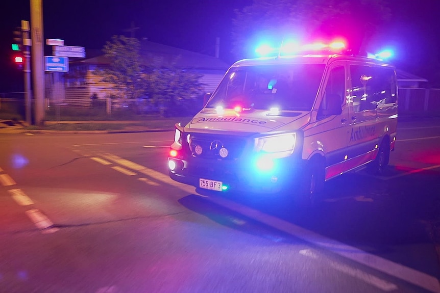 Ambulance rushing along a road with lights on