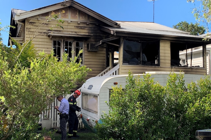 Police and forensic investigators at fire-ravaged Queenslander home at Clayfield.
