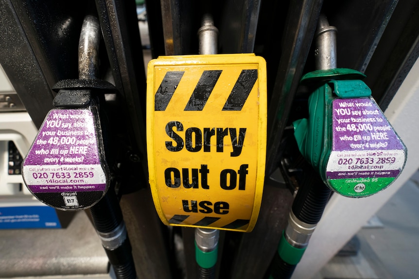 An out of use sign is seen on a pump at a petrol station