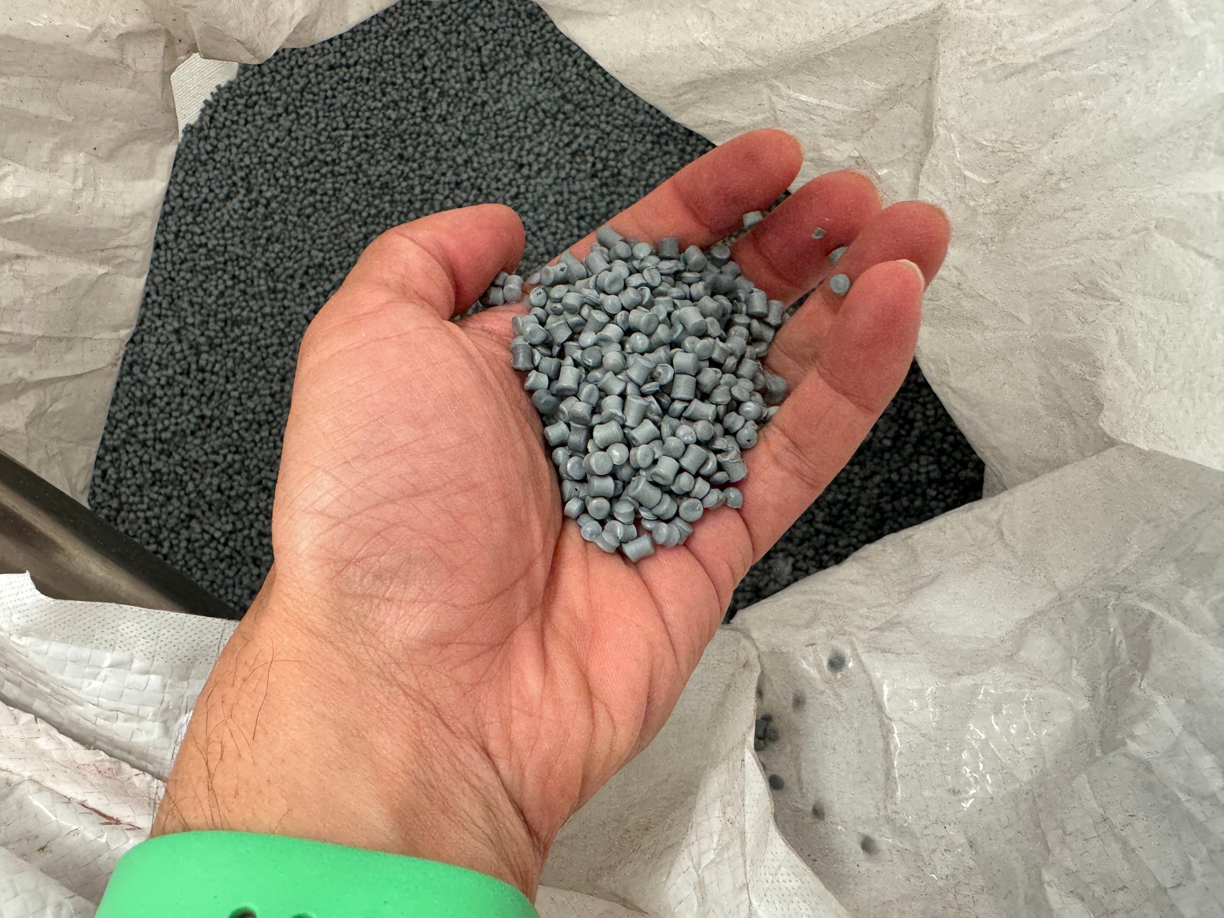 A hand holding plastic pellets