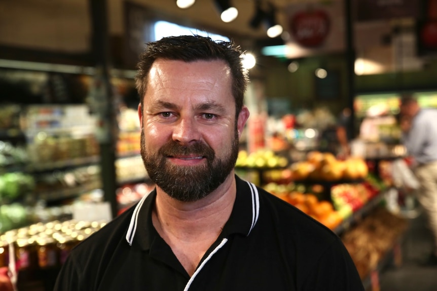 Craig Williams stands in the fruit and veg section of the supermarket he manages.