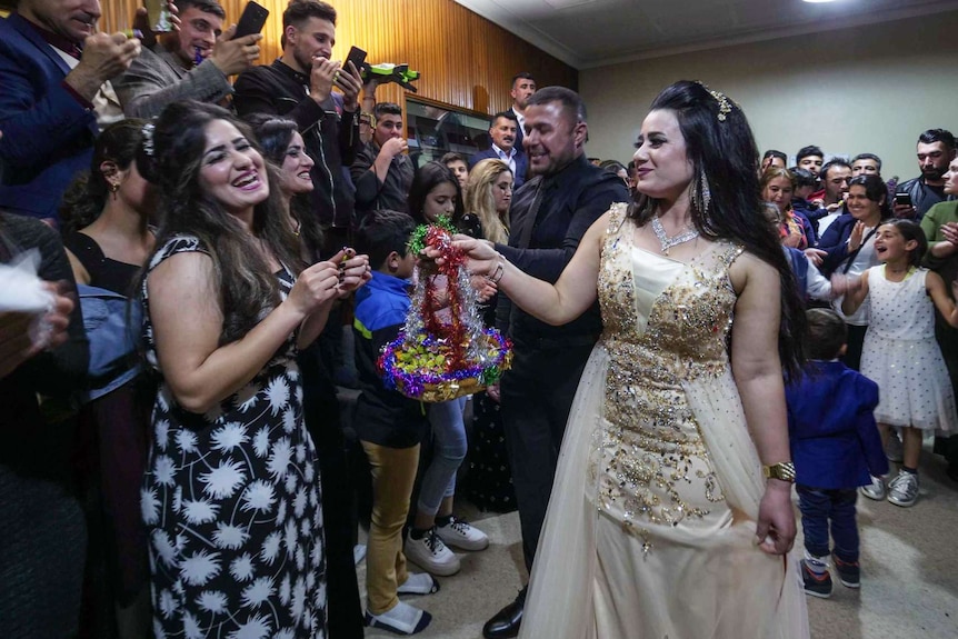 A woman celebrates her engagement by handing out candy to family and friends.