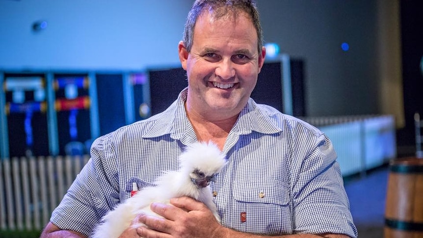 Man holding a chook.