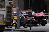 A car is seen crushed and damaged after being driven through busy Bourke St mall.
