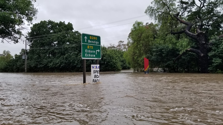 A road sign surrounded by flood water.