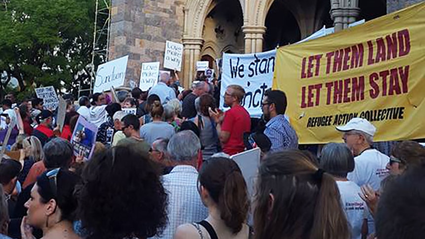 A group of refugee supporters gathers outside Brisbane's St John's Cathedral