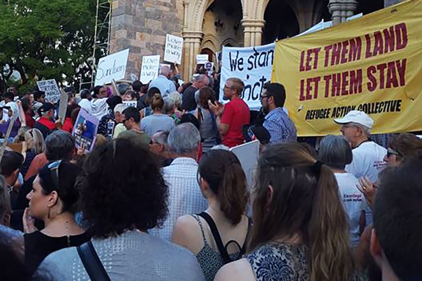 A group of refugee supporters gathers outside Brisbane's St John's Cathedral