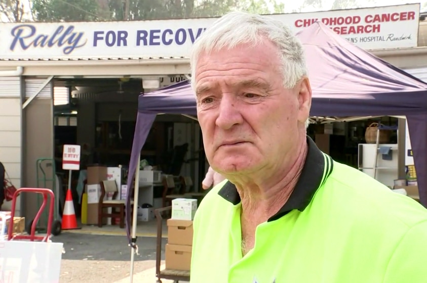 Ken Sloane stands in front of the Rally for Recovery fundraising tent