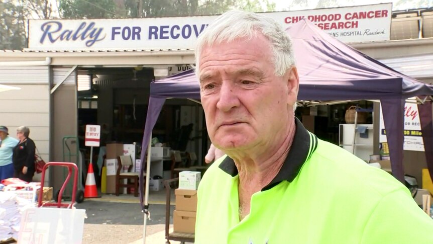 Ken Sloane stands in front of the Rally for Recovery fundraising tent