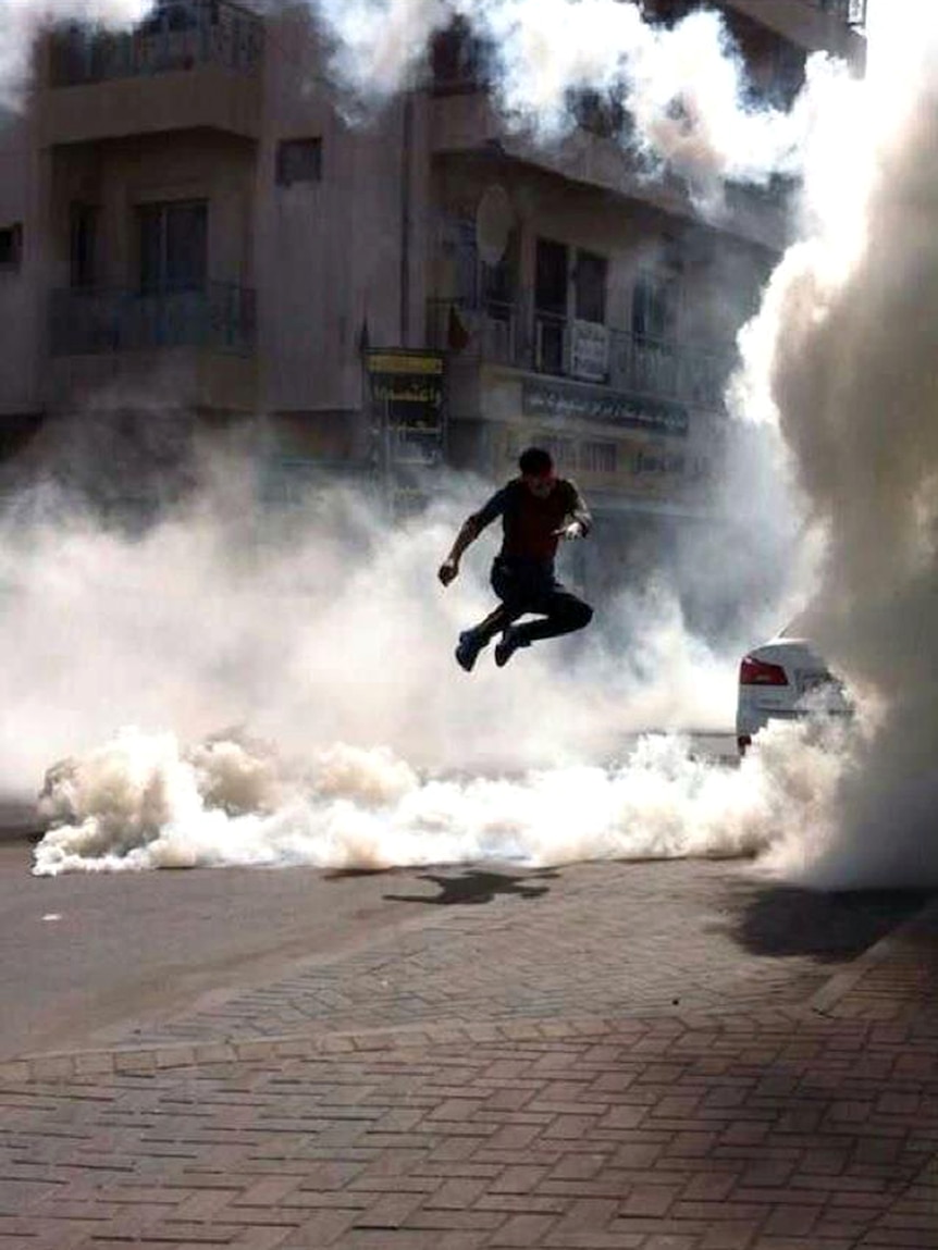 Bahrain protester runs from tear gas