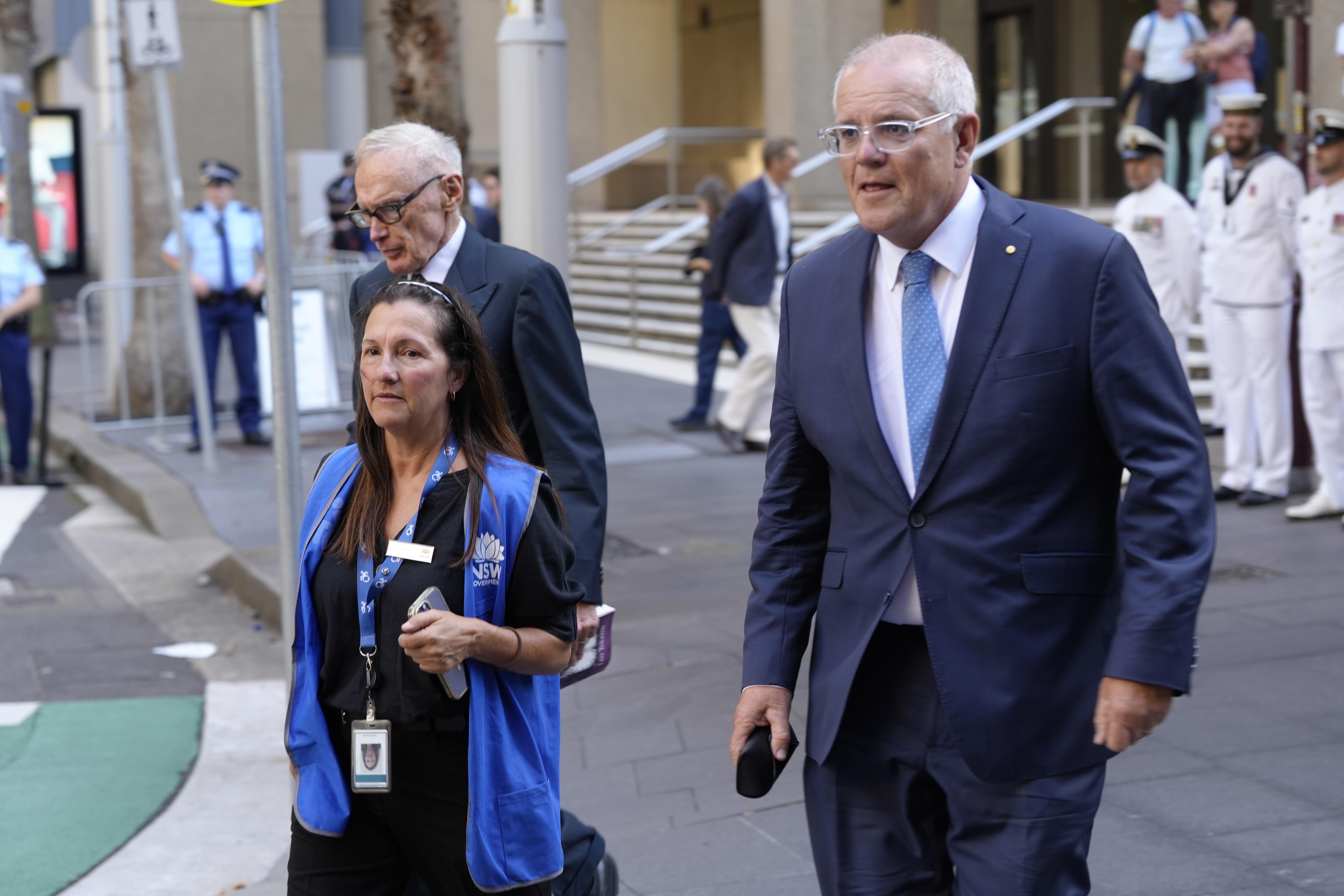 Scott Morrison e Bob Carr do lado de fora da igreja vestindo ternos escuros.
