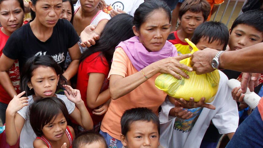 Flash flood victims queue for relief goods outside an evacuation centre in Iligan city.