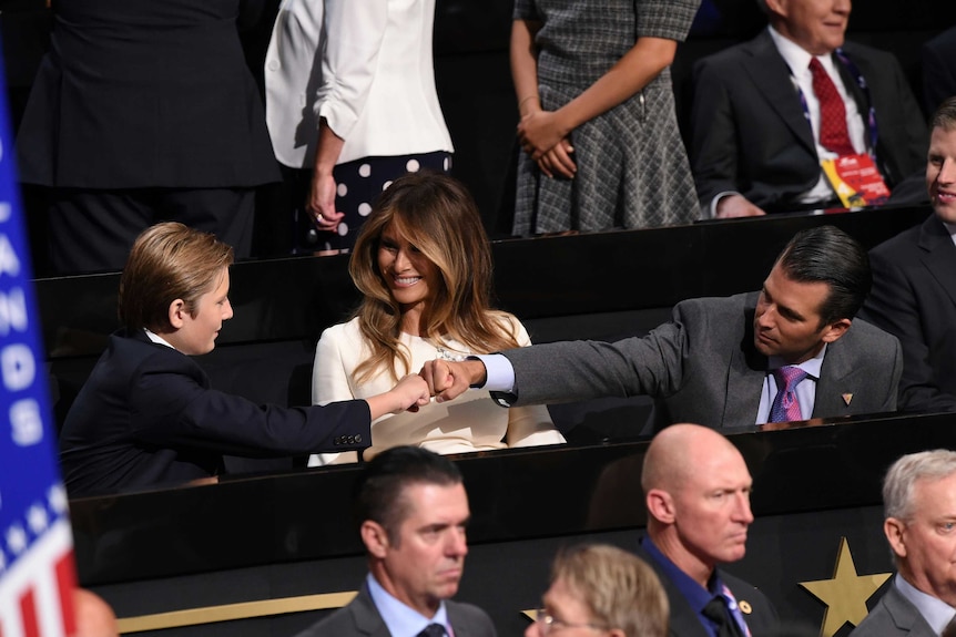 Barron Trump fist bumps older brother Donald Jr. Melania Trump is in between them