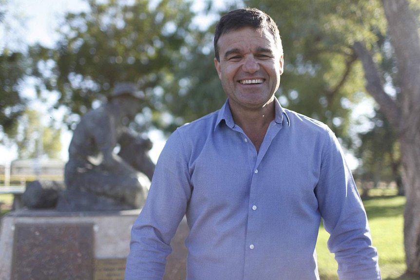 Winton Shire Council Mayor Gavin Baskett stands smiling in a street in the western Queensland town.