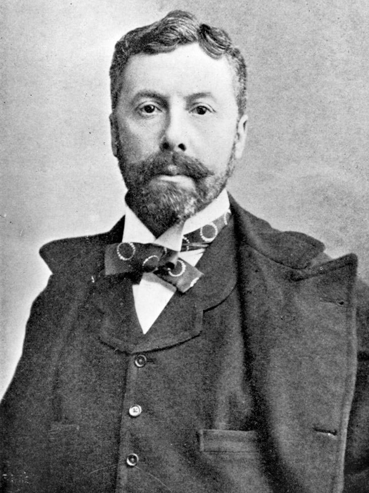 Black and white photo of a Victorian-era man with a beard and a styled haircut.