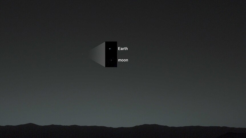 A mostly black image with faint bright dots of the Earth and the Moon as seen from Mars