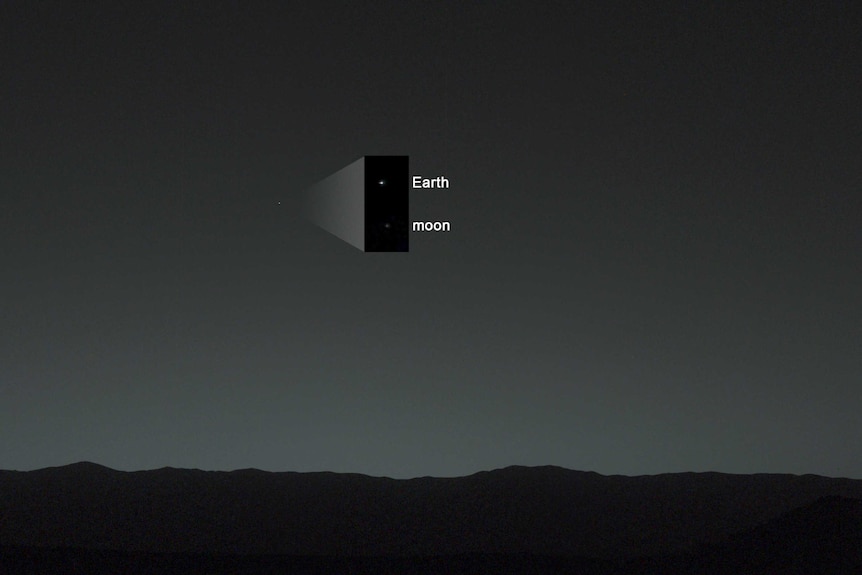 A mostly black image with faint bright dots of the Earth and the Moon as seen from Mars