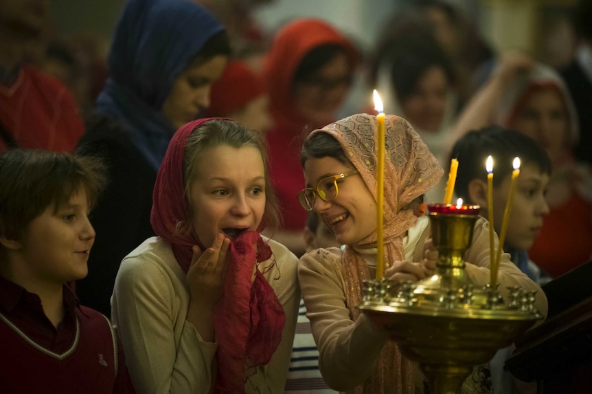 Two Girls react during the Easter service at a church near the Kremlin Wall in Moscow.
