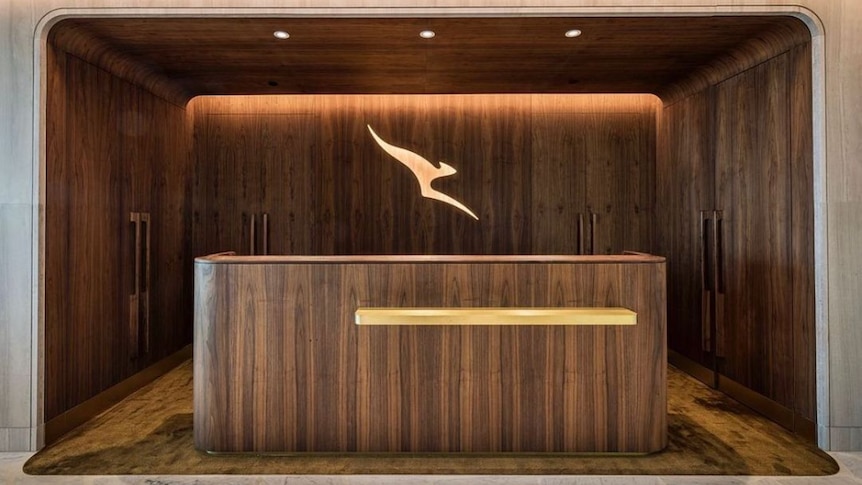 A sleek wooden desk with the Qantas logo above it.