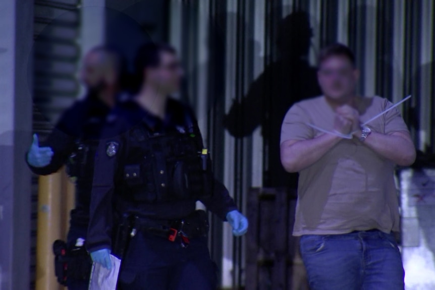 A man in handcuffs with a police officer.
