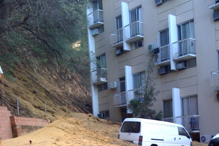 Landslide outside a block of apartments which had to be evacuated after the storm swept through in P