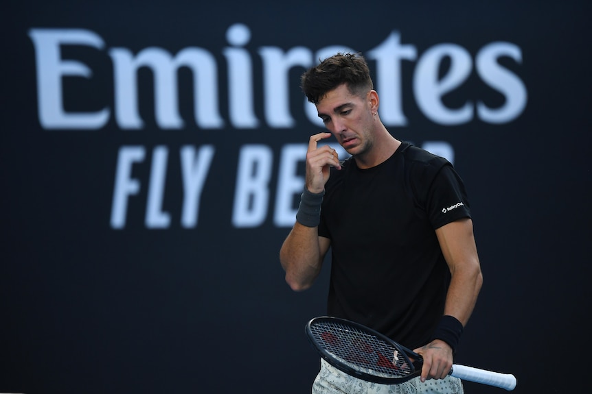 Tennis player looks defeated.