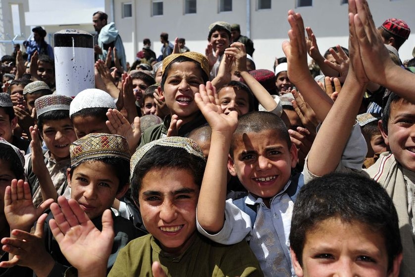 A group of children in Afghanistan clap and cheer.