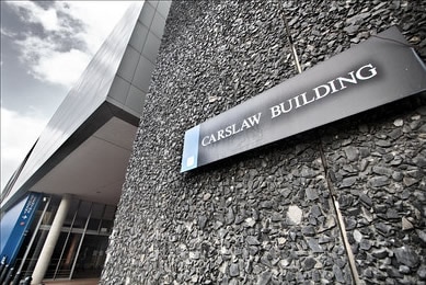 A grey building with the sign Carslaw Building.