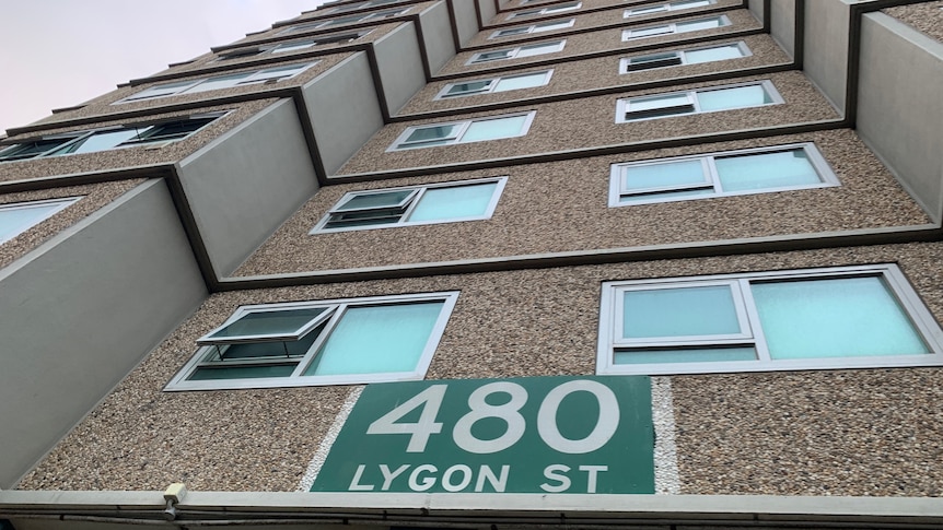 A ground view close to the public housing tower, looking up, with a '480 Lygon St' sign visible.