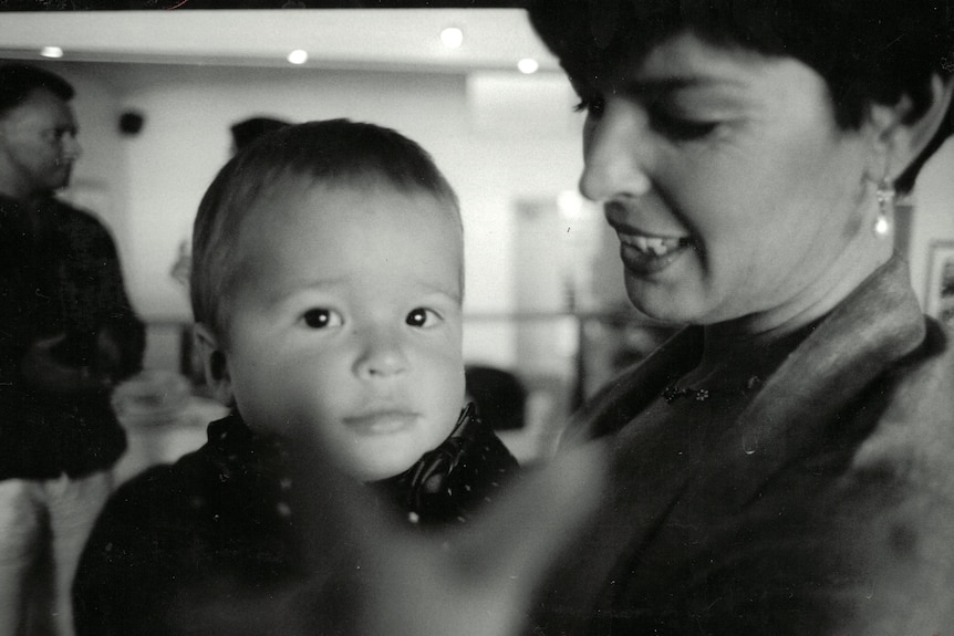 Black and white photo of a woman holding a baby.