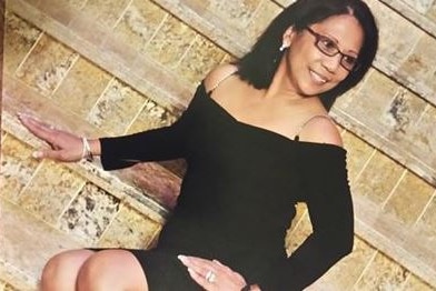 Marilou Danley wears a black dress in a glamour shot on stairs.