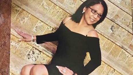 Marilou Danley wears a black dress in a glamour shot on stairs.