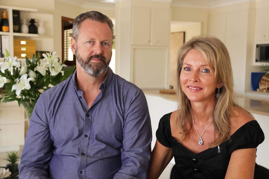 Sara Zelenak's parents, Mark and Julie Wallace, hold hands in their home in Brisbane.