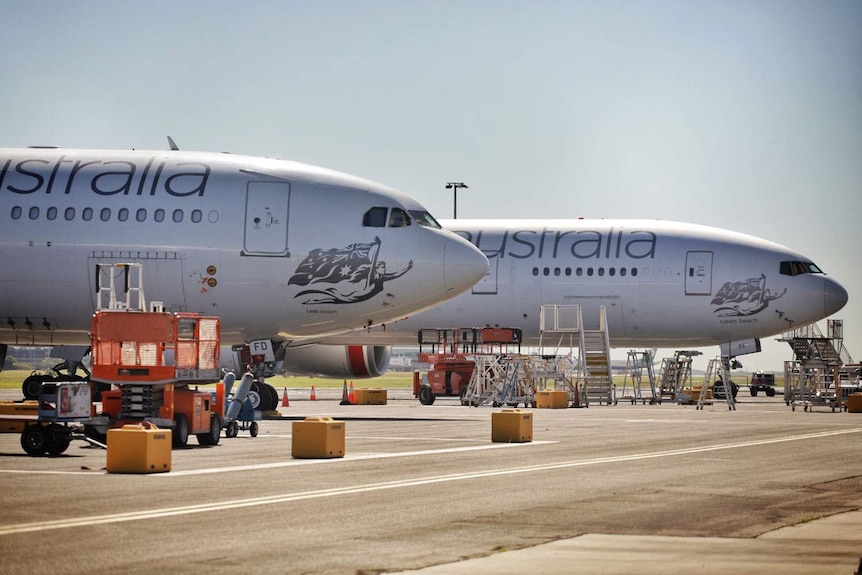 Two landed Virgin Australia aircraft with ground crew operations at Brisbane Airport.