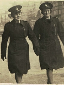 Kathleen Golder in a policewoman uniform walking with another woman.