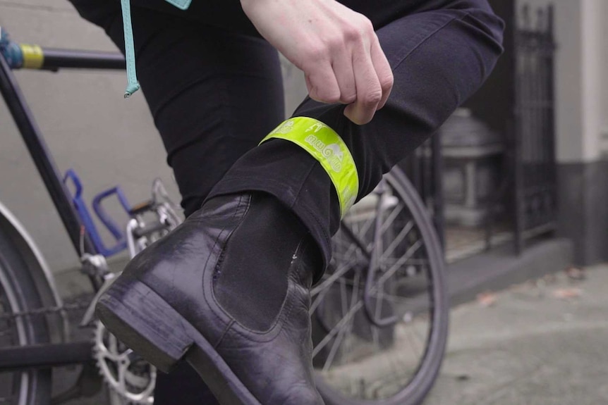 A close up of Julia's right leg, she is wearing a fluroscent band arounf her ankle that will help drivers spot her at night.