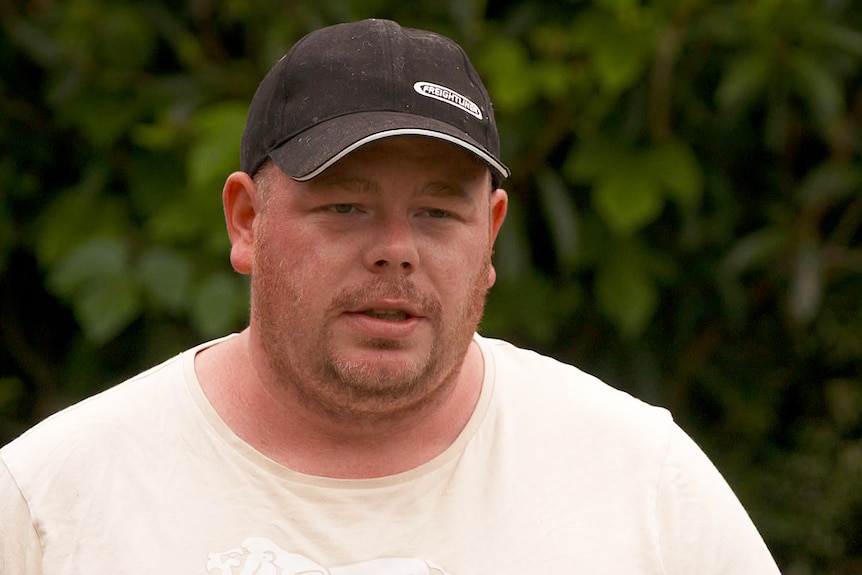 A man wearing a cap and t-shirt