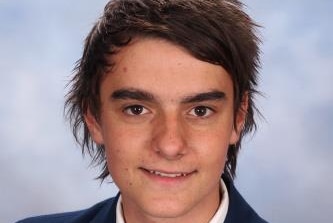 A young man poses for a school photo.