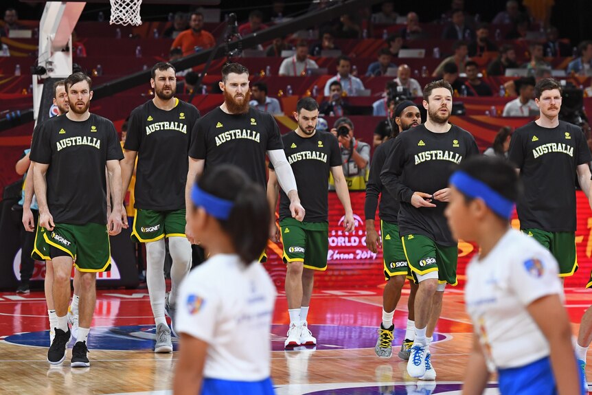 Australian Boomers players walk on the court before a 2019 FIBA World Cup game against Spain.