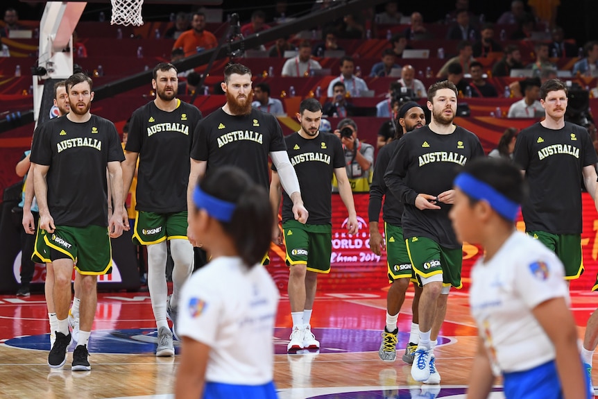 Australian Boomers players walk on the court before a 2019 FIBA World Cup game against Spain.