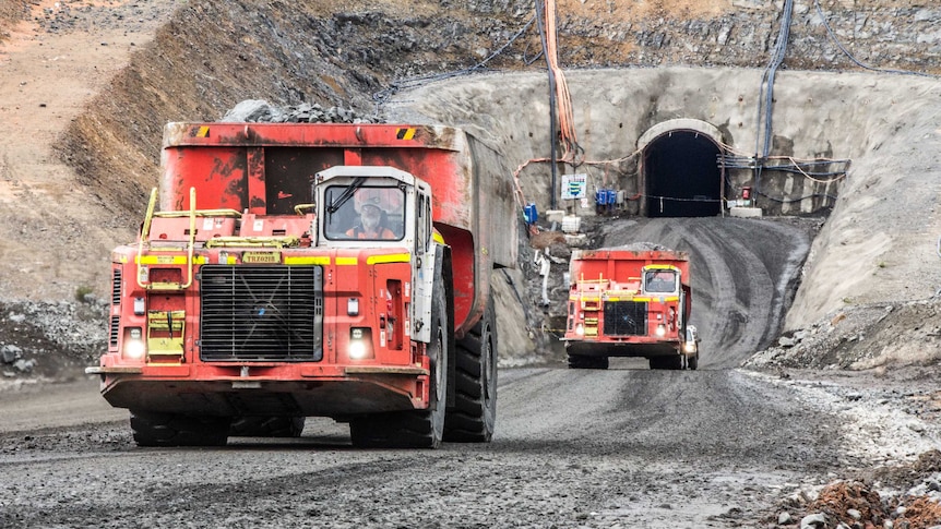 Mining trucks at the entrance to an underground mine.