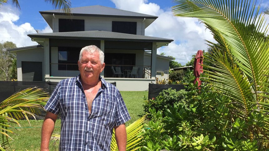 Graham Don stands in front of his newly constructed home after the former property was destroyed by Cyclone Yasi.