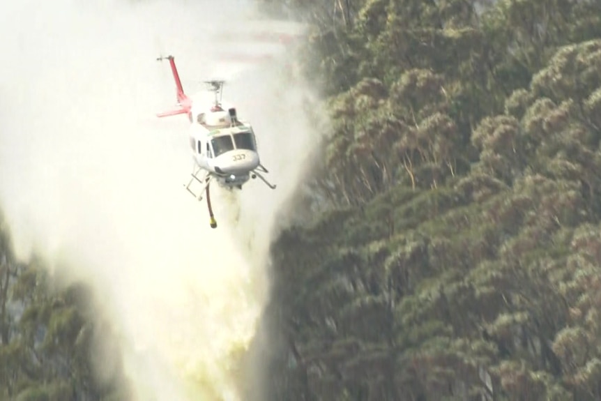 helicopter drops water on fire.