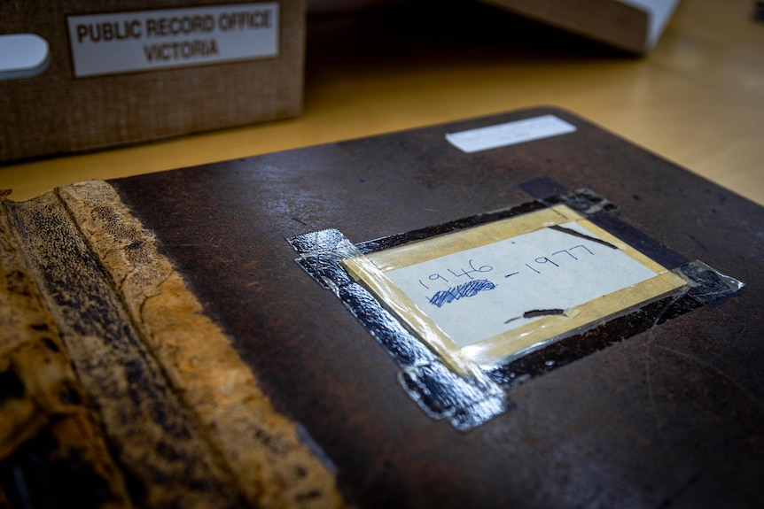 A battered leather-bound ledger book.