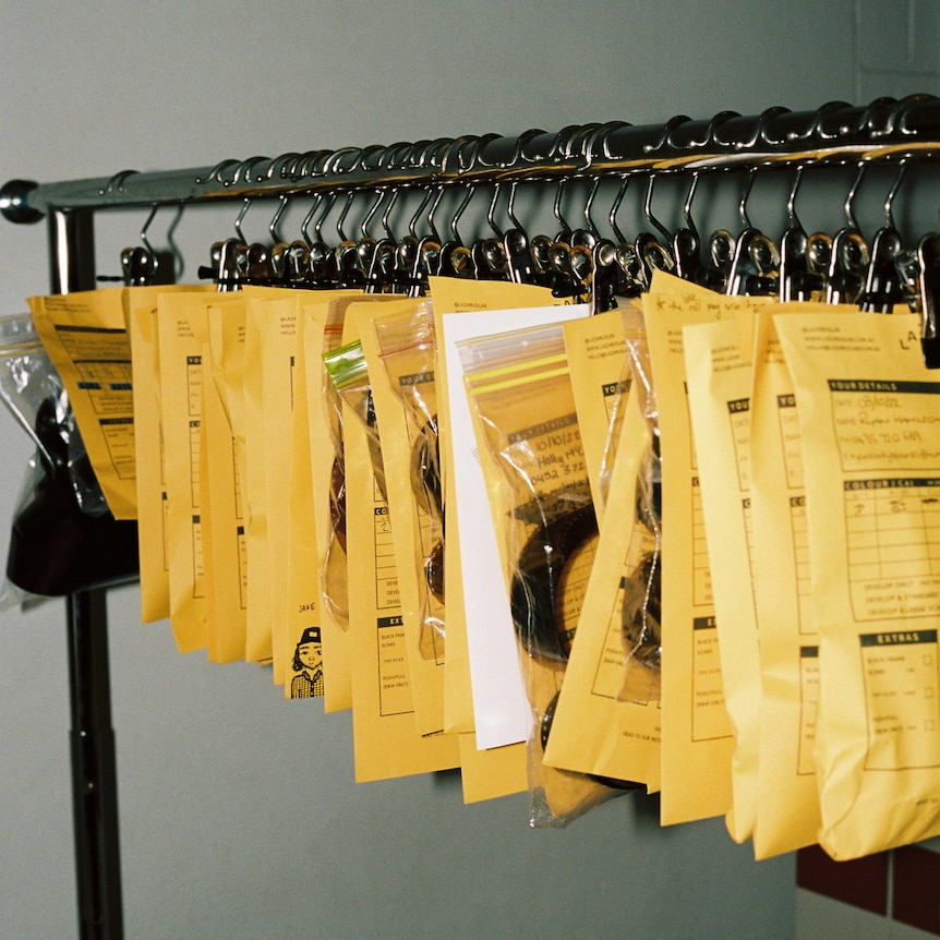 Packages of film lined up hanging from a coat rack